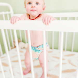 baby standing in cloth with cloth nappy on